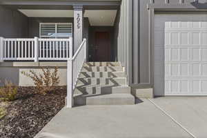 Entrance to property featuring a porch and a garage