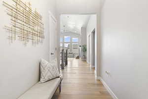 Hall featuring light wood-style flooring and lofted ceiling