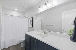 Full bath featuring dark wood finished floors, vanity, shower / bath combo, and recessed lighting