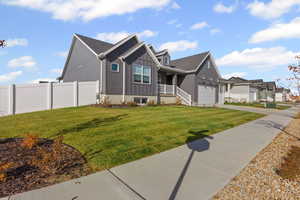 View of front of home with board and batten siding, a porch, concrete driveway, a garage, and a residential view