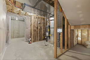 Unfinished basement featuring heating unit and water heater