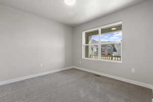 Empty room with carpet floors and baseboards