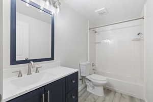 Full bath with vanity, shower / bath combination, and light wood-style flooring