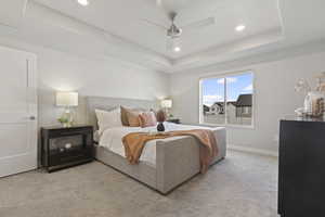 Bedroom with a raised ceiling, light colored carpet, a ceiling fan, and recessed lighting