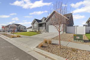 View of front facade with a gate, concrete driveway, a porch, board and batten siding, and a residential view
