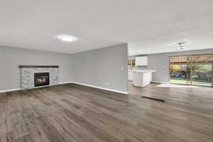 Unfurnished living room with dark wood-style floors, a fireplace, and recessed lighting