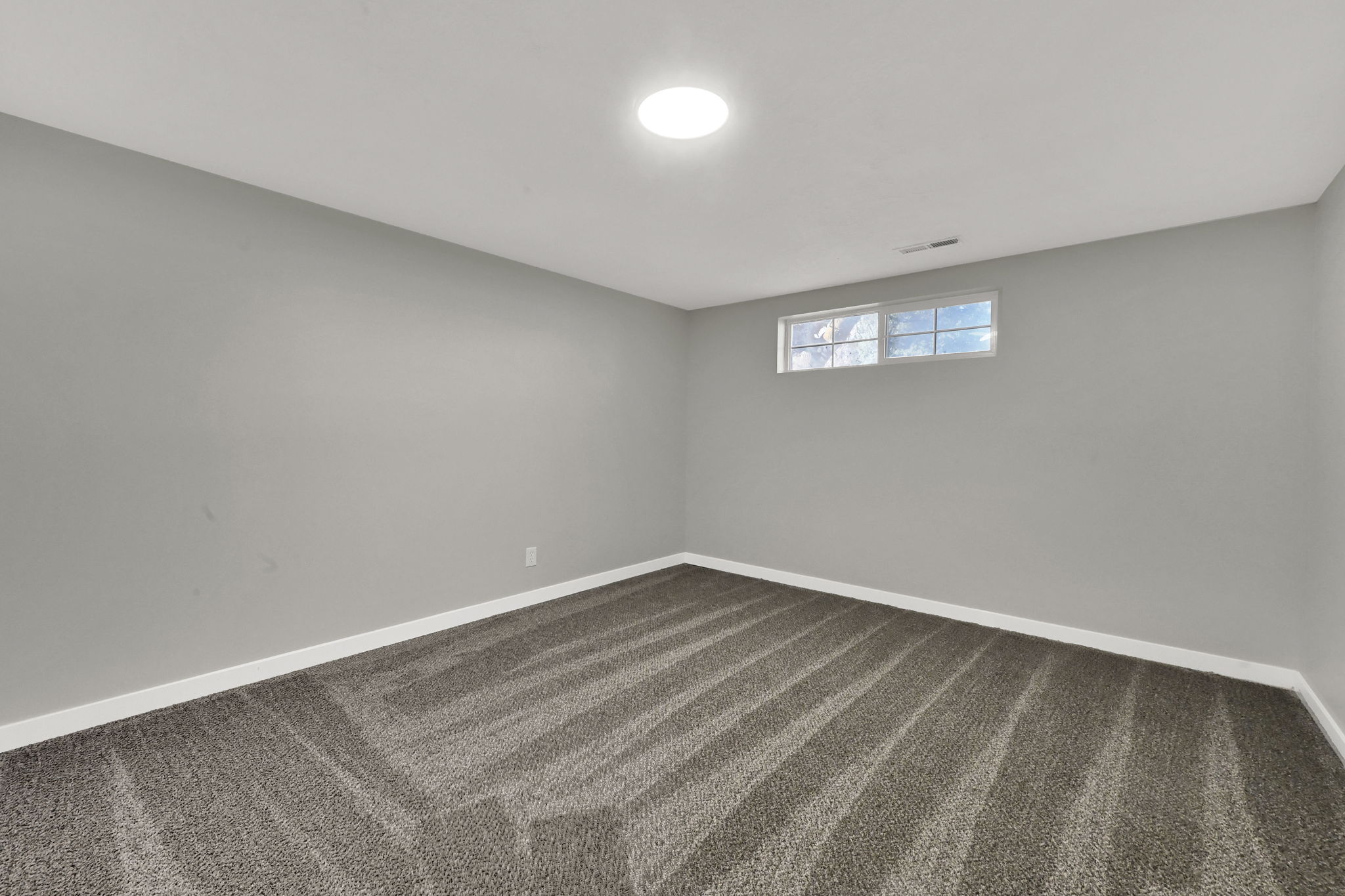 Spare room with dark colored carpet and baseboards