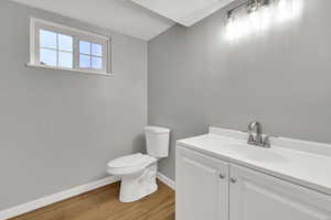 Half bath with vanity and light wood-style flooring