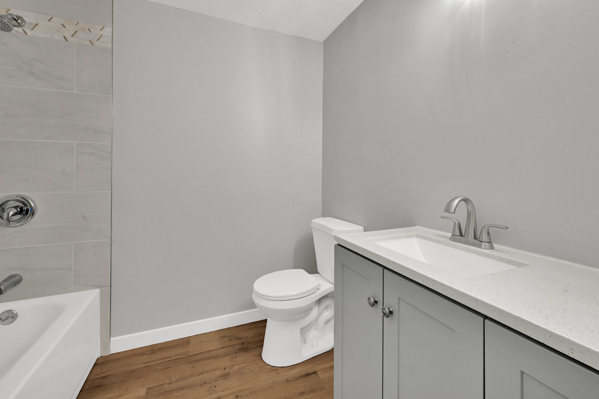 Bathroom featuring vanity, light wood-style floors, and  shower combination