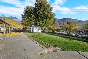 Fenced backyard with a mountain view and a storage shed