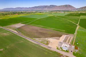 Overview of rural landscape featuring large plots for crops and a mountain backdrop