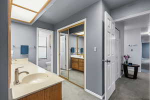 Full bathroom featuring light colored carpet, double vanity, and a textured ceiling