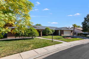 Ranch-style home with brick siding, a front yard, driveway, and an attached garage