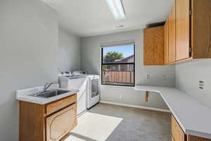 Laundry room featuring cabinet space, light carpet, and washing machine and clothes dryer