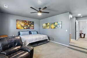 Carpeted bedroom with a textured ceiling and ceiling fan