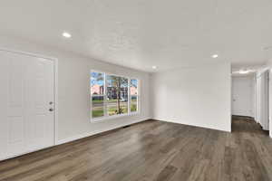 Entrance foyer featuring recessed lighting, dark wood-style flooring, and a textured ceiling