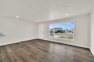 Empty room featuring wood finished floors, recessed lighting, and a textured ceiling