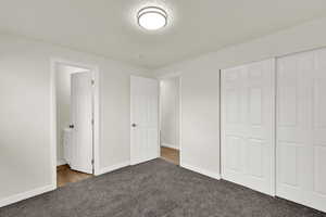 Unfurnished bedroom with carpet flooring, a textured ceiling, and a closet