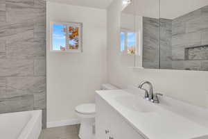 Full bathroom with vanity, light tile patterned floors, and a textured ceiling