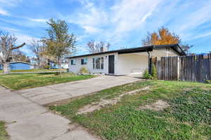 Ranch-style home featuring a chimney, an attached carport, and concrete driveway