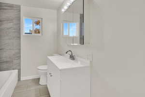 Bathroom with vanity, light tile patterned floors, plenty of natural light, and a textured ceiling
