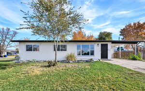 Ranch-style home featuring an attached carport and concrete driveway