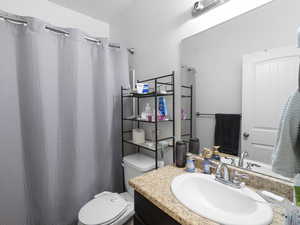 Full bath featuring curtained shower and vanity