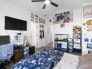 Bedroom featuring lofted ceiling, carpet flooring, and a ceiling fan