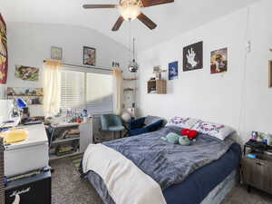 Bedroom featuring vaulted ceiling, carpet flooring, and a ceiling fan