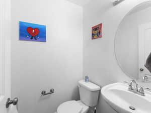 Half bath featuring a sink and toilet