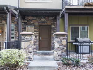 Doorway to property featuring stone siding and stucco siding