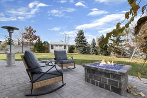 Fenced backyard with a fire pit, a patio area, and a storage shed