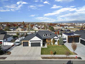 View of front facade featuring driveway, a residential view, and a garage