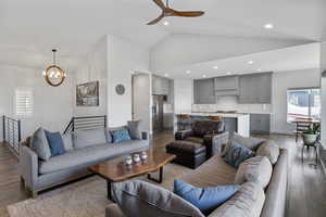 Living area featuring healthy amount of natural light, dark wood-type flooring, a chandelier, a ceiling fan, and recessed lighting