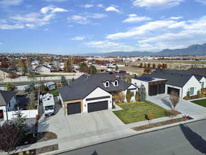 View of front of property featuring a residential view, concrete driveway, an attached garage, and a mountain view