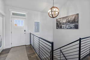 Entryway featuring dark wood-type flooring and a chandelier