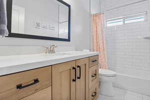 Bathroom featuring vanity, light tile patterned floors, and shower / bathtub combination with curtain