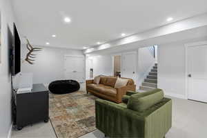 Living room featuring carpet flooring, recessed lighting, and stairway