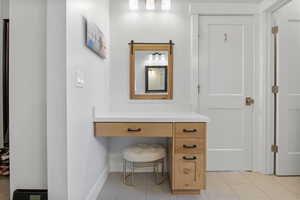 Bathroom with light tile patterned flooring and vanity