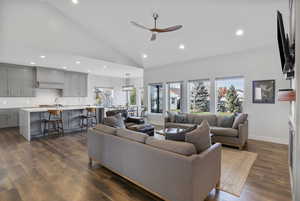 Living area with recessed lighting, a ceiling fan, dark wood finished floors, and high vaulted ceiling