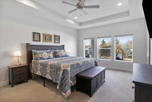Bedroom with carpet, a raised ceiling, ceiling fan, and recessed lighting