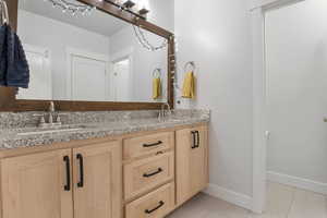 Bathroom with double vanity and light tile patterned floors