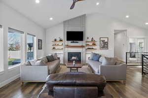 Living room featuring recessed lighting, wood finished floors, a large fireplace, vaulted ceiling, and ceiling fan