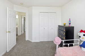 Carpeted bedroom with a closet and baseboards