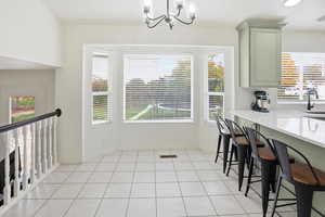 Dining area featuring light tile patterned floors, a chandelier, and recessed lighting