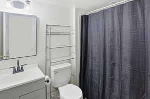 Bathroom featuring a textured ceiling, vanity, and a shower with shower curtain