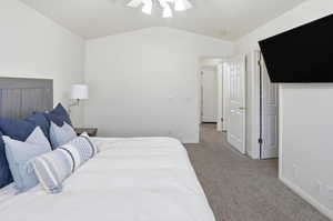 Bedroom featuring carpet floors, lofted ceiling, and a ceiling fan