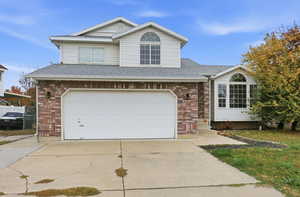 Traditional-style home with brick siding, concrete driveway, and an attached garage