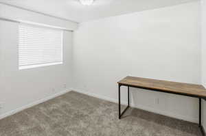 Unfurnished office featuring carpet and baseboards