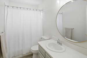 Full bathroom with vanity, light wood-type flooring, and shower / bath combo